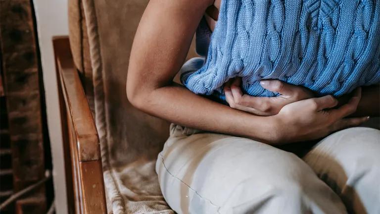 Person holding their stomach in pain