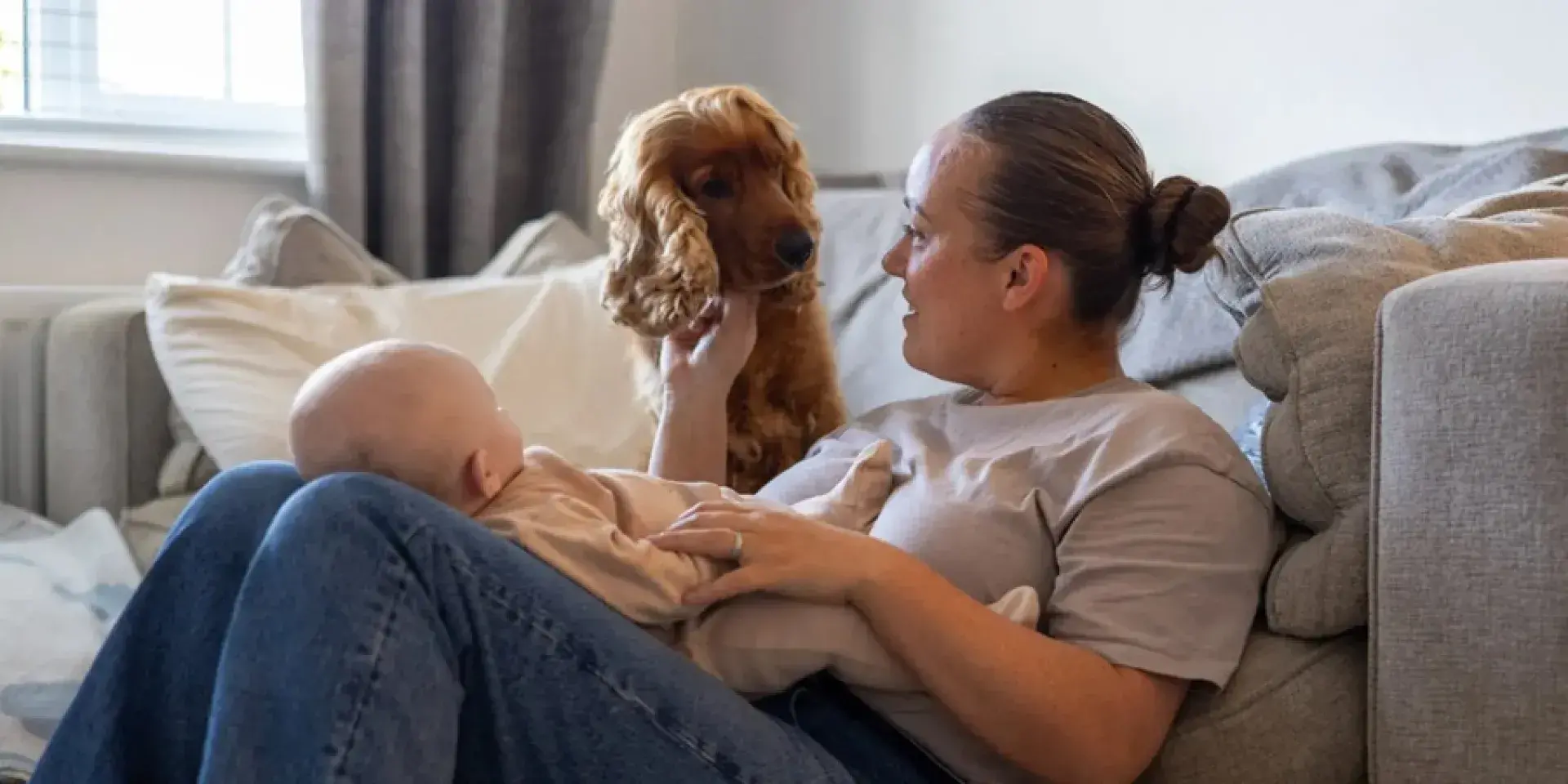 Mother with baby and dog on a sofa