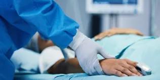 Medical professional checking pulse of hospital patient