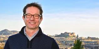 Head shot of Professor Joris Veltman against Edinburgh skyline