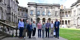 Line up of people in front of University buildings