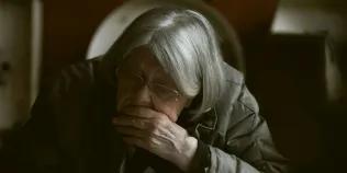 elderly woman with chin in hands