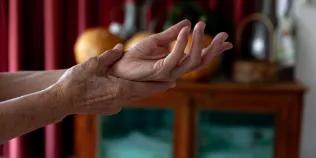 Woman supporting left wrist in right hand