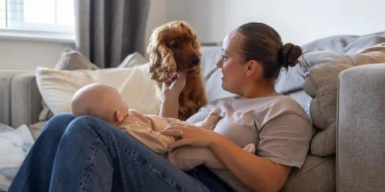 Mother with baby and dog on a sofa
