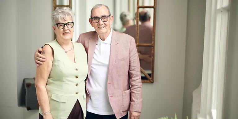 Elderly couple standing in hallway