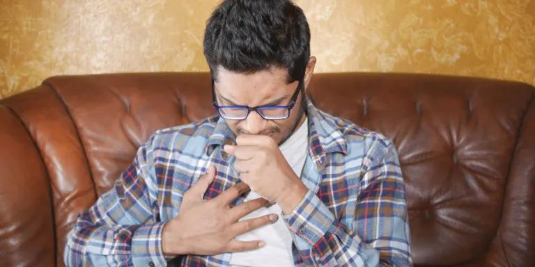Man coughing and holding chest