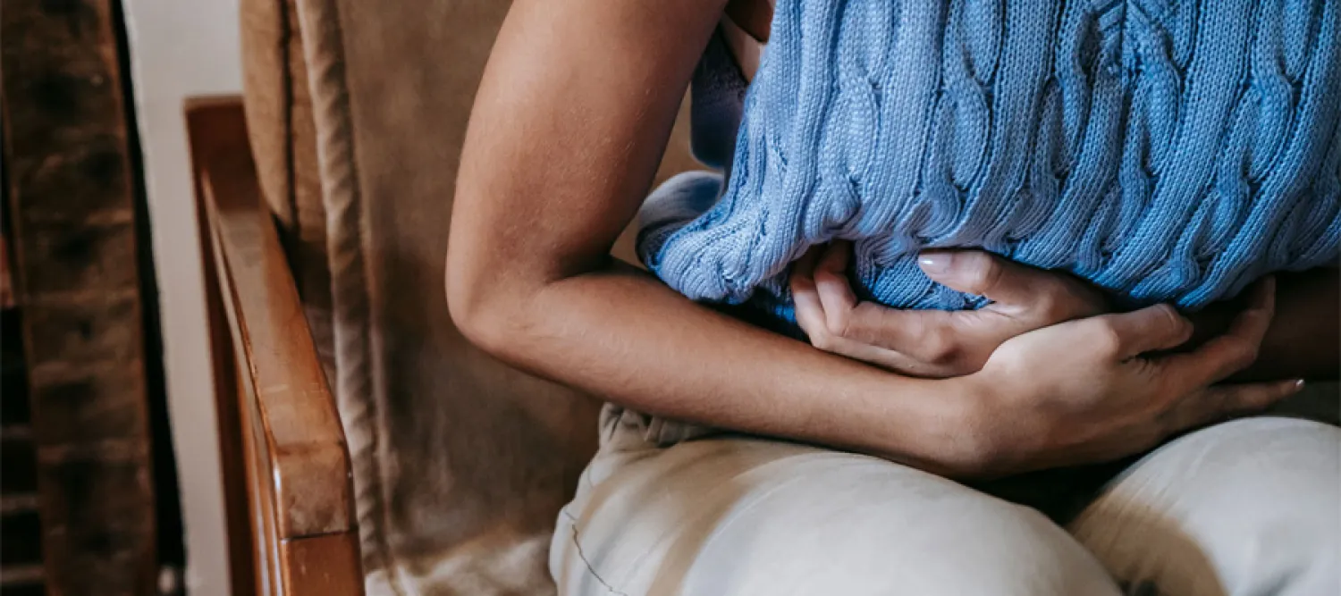 Person holding their stomach in pain