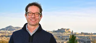 Head shot of Professor Joris Veltman against Edinburgh skyline