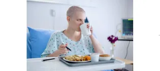 Cancer patient in hospital drinking and eating