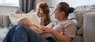 Mother with baby and dog on a sofa