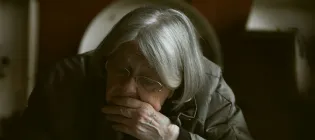 elderly woman with chin in hands