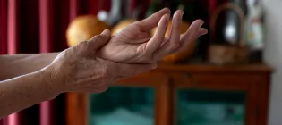 Woman supporting left wrist in right hand