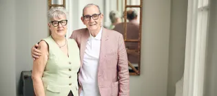 Elderly couple standing in hallway