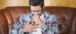 Man coughing and holding chest