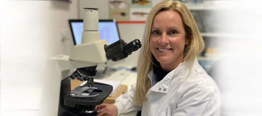 Canine oral cancer study (scientist sitting next to a microscope)