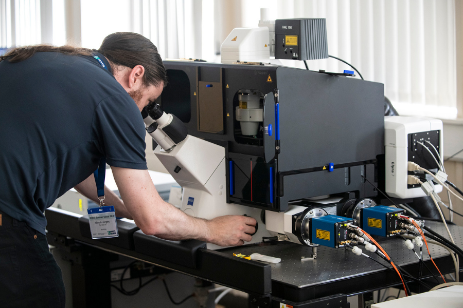 ESRIC Summer School attendee looking down a microscope